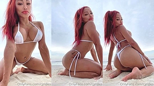 red hair busty onlyfans model CJ Miles seat on the beach and shows her booty