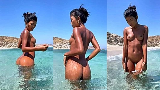 slutty onlyfans model Tita Sahara laysdown in the beach sand and gets water splach in her wet coochie